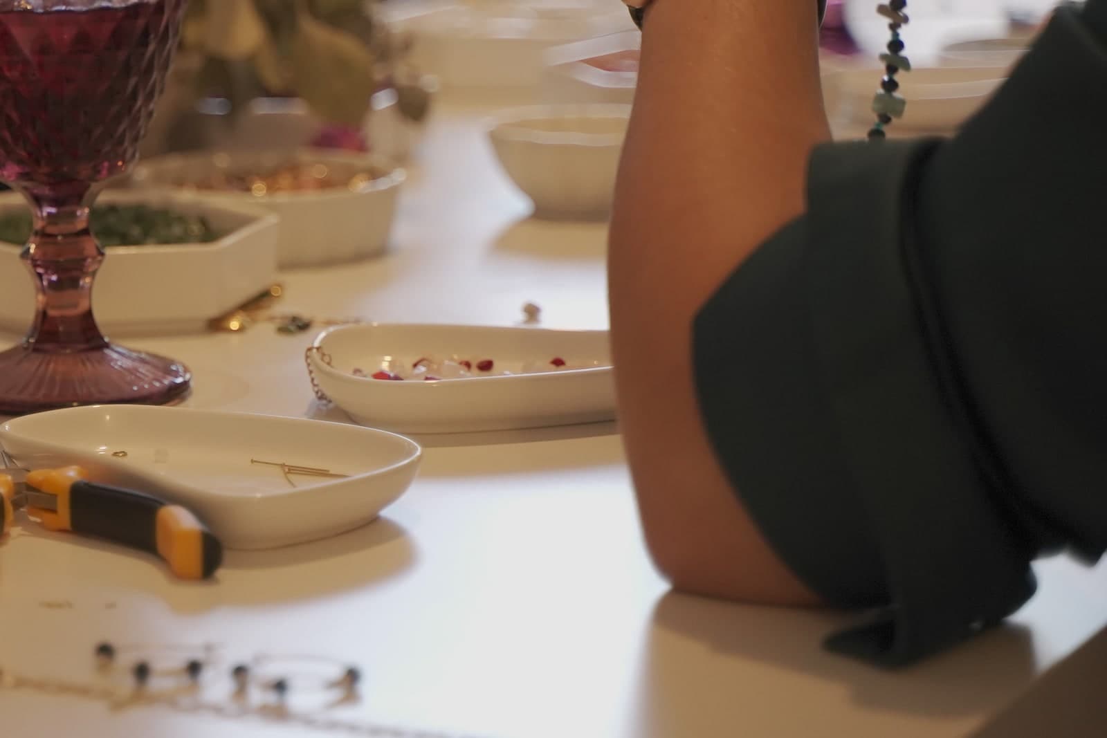 Detalle de manos creando una joya en la mesa de Joyas y Sangría