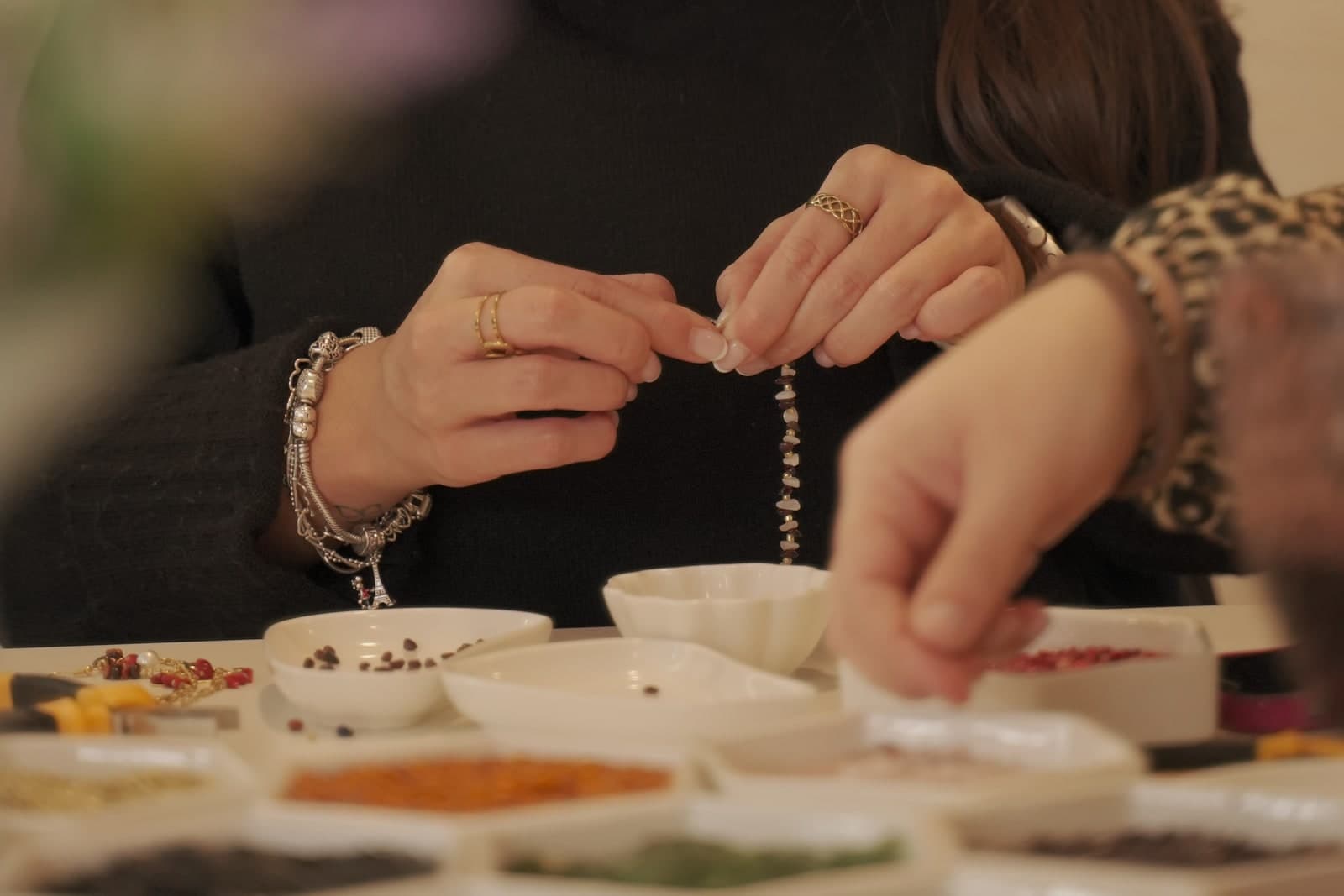 Detalle de manos creando una joya en la mesa de Joyas y Sangría