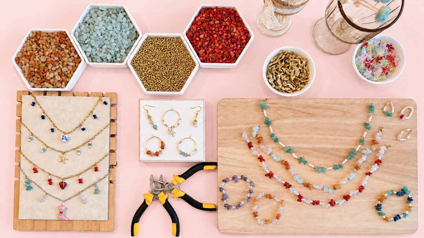 Mesa rosa con minerales, herramientas, collares, pulseras y pendientes hechos a mano