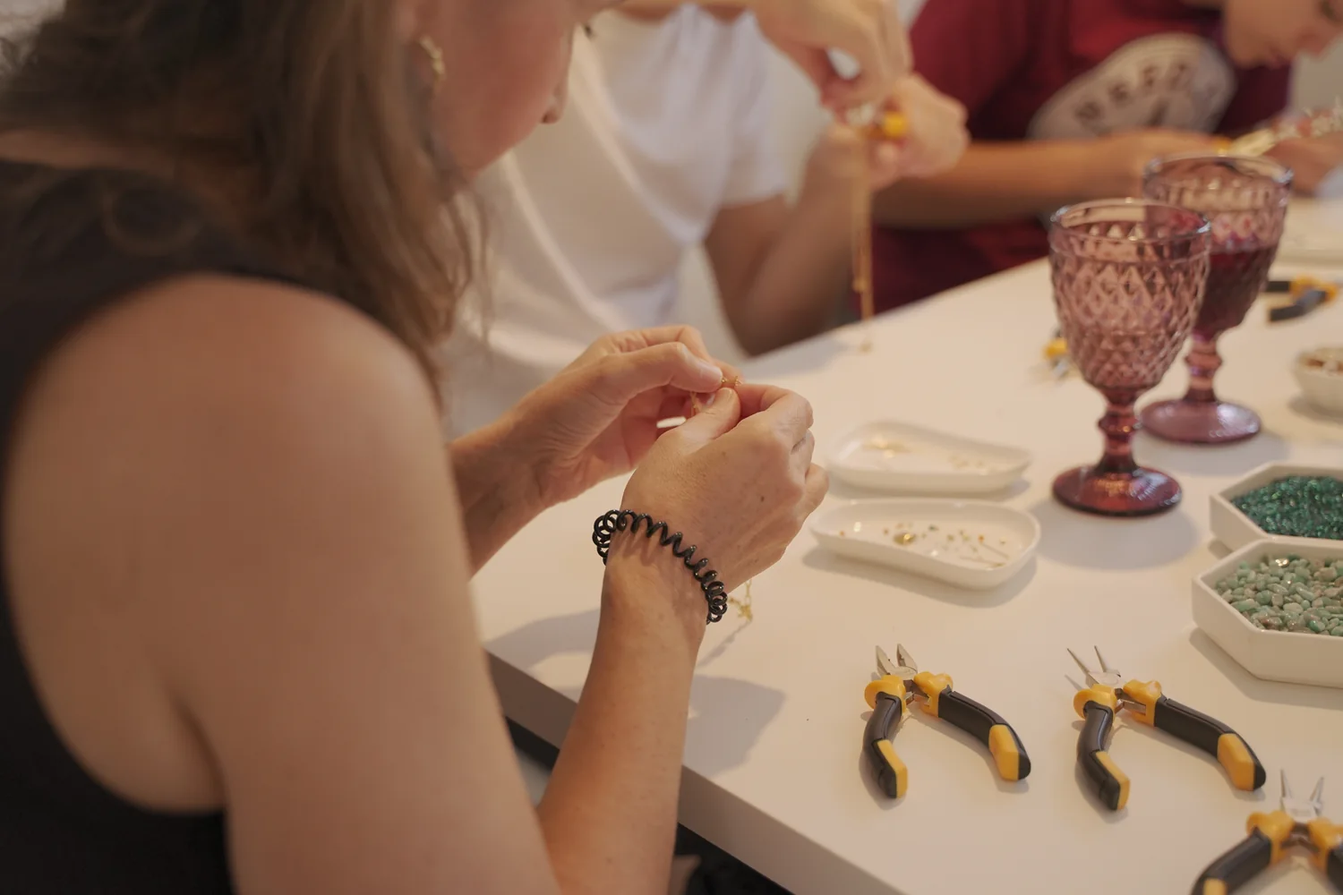 Participante montando una joya con herramientas y materiales del taller
