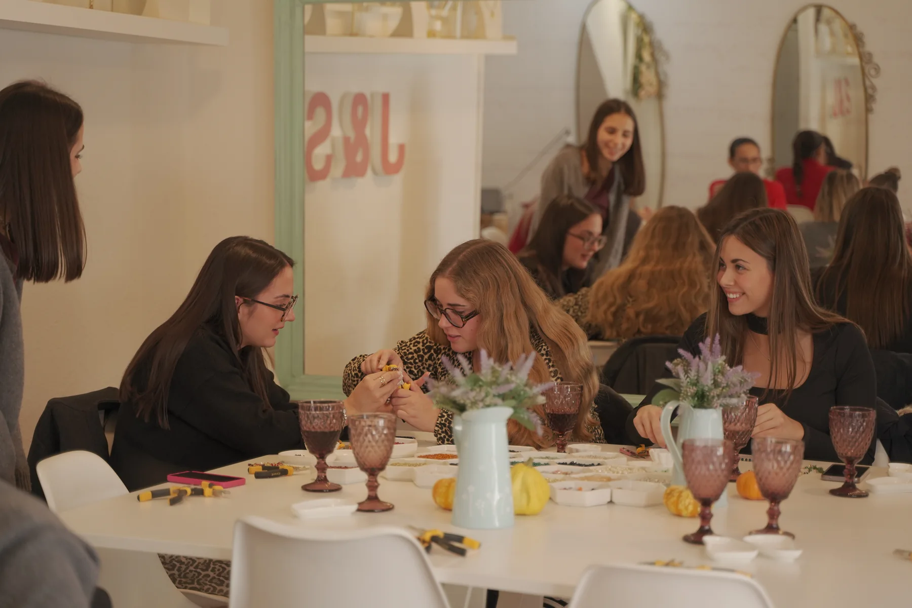 Grupo de participantes creando joyas juntas alrededor de la mesa del taller